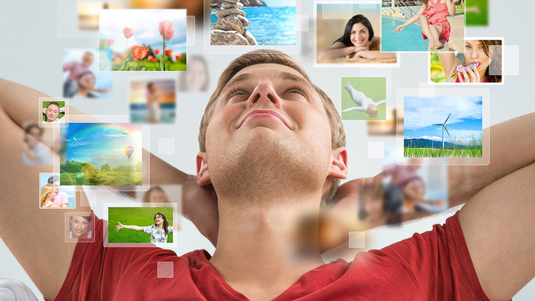 Tyytyväinen nuori leijuvien valokuvien ympäröimänä