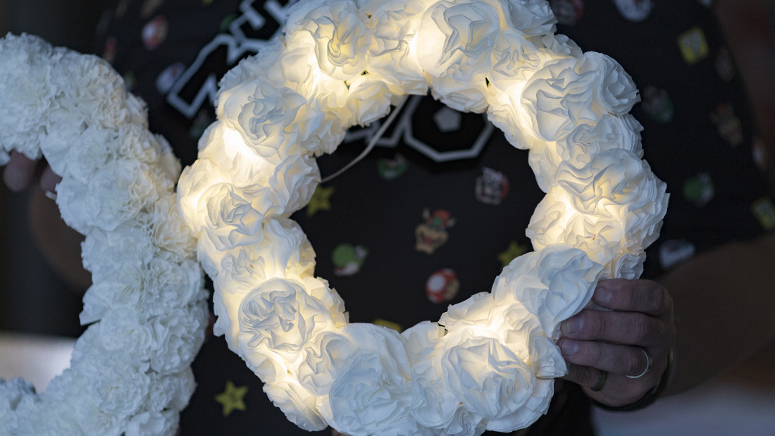 Valkoinen seppele loistaa valoa sisältäpäin.