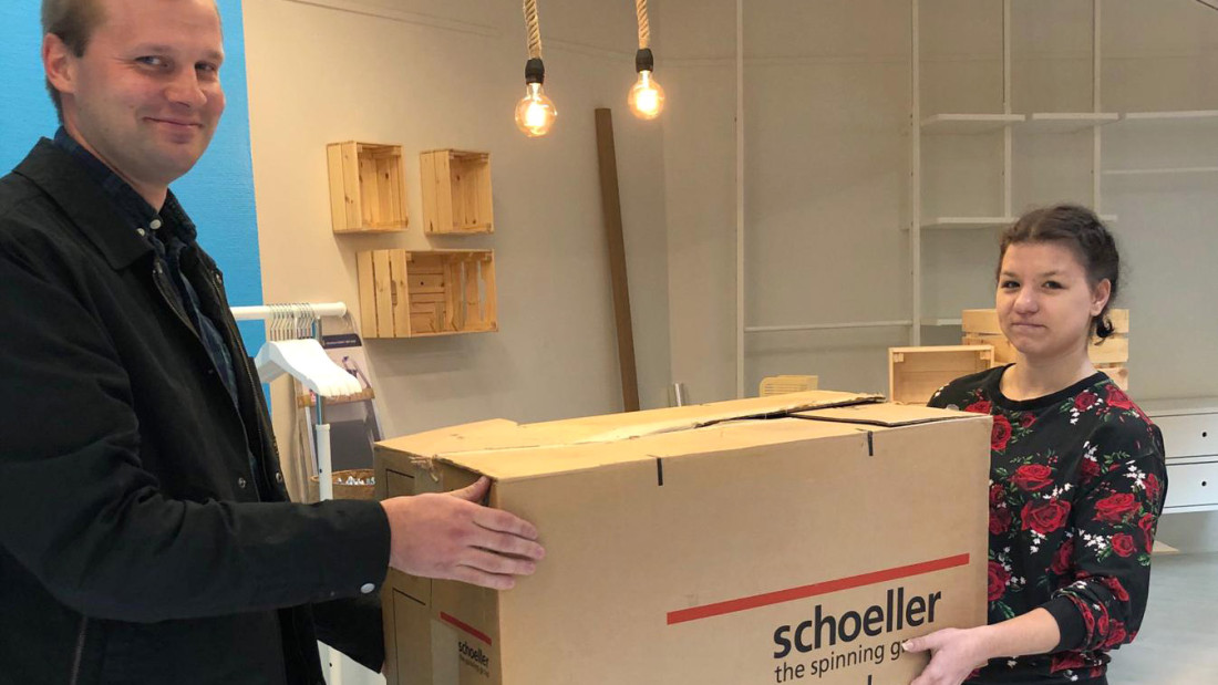 opiskelija ottaa Merinollan yrittäjältä vastaan ison laatikollisen tuotteita