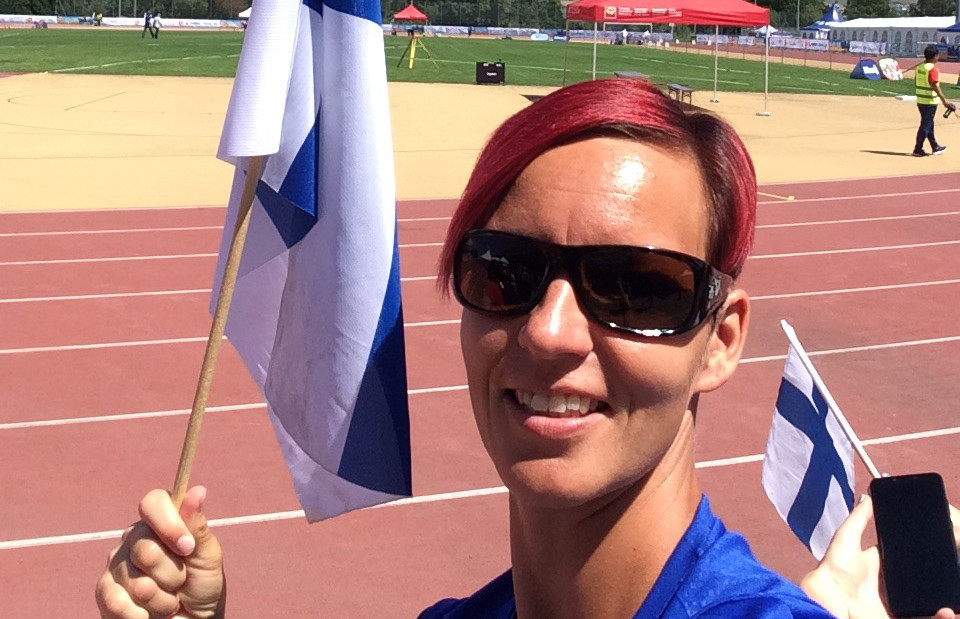 Hanna Kasurinen urheilukentällä, Suomen lippu kädessään.
