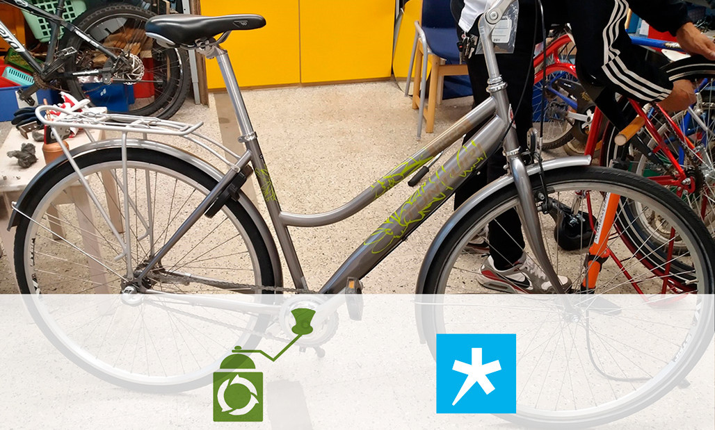 Polkupyörä huollossa, alaosassa Kierrätysmyllyn ja Spesian logot yhteistyön merkiksi.