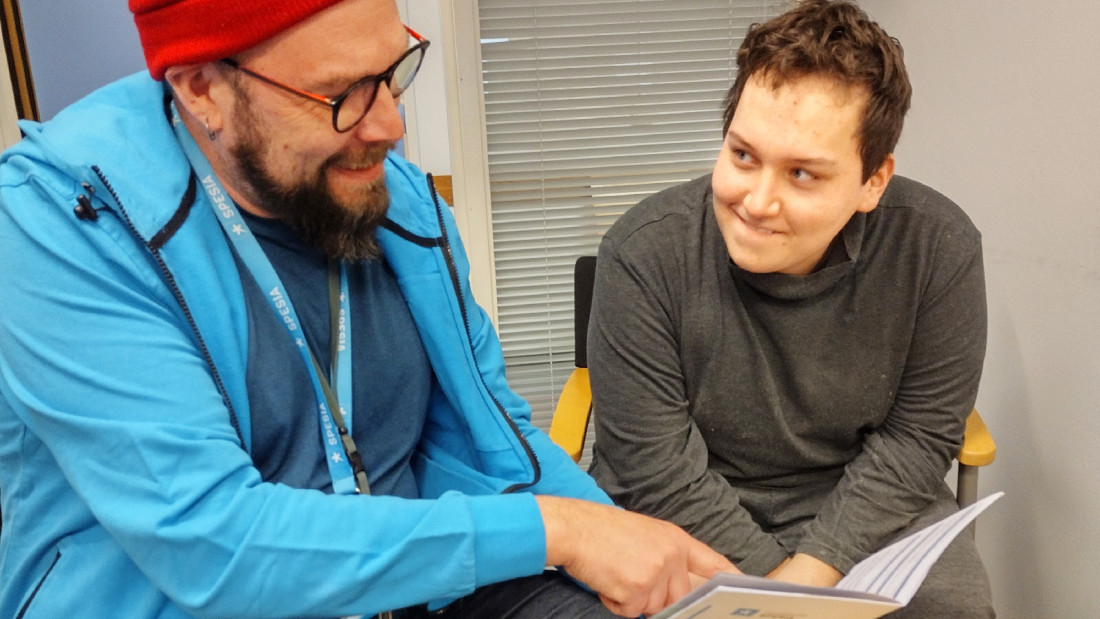 Vesa Tomberg esittelee Spesian hakijan opasta nuorelle.