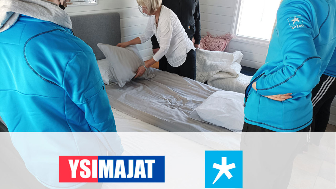Ysimajan ja spesian logot kuvan päällä, jossa nainen näyttää opiskelijoille sängyn petausta.