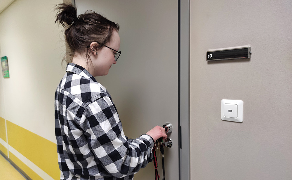 Opiskelija avaa oman asuntonsa ovea asuntolassa.