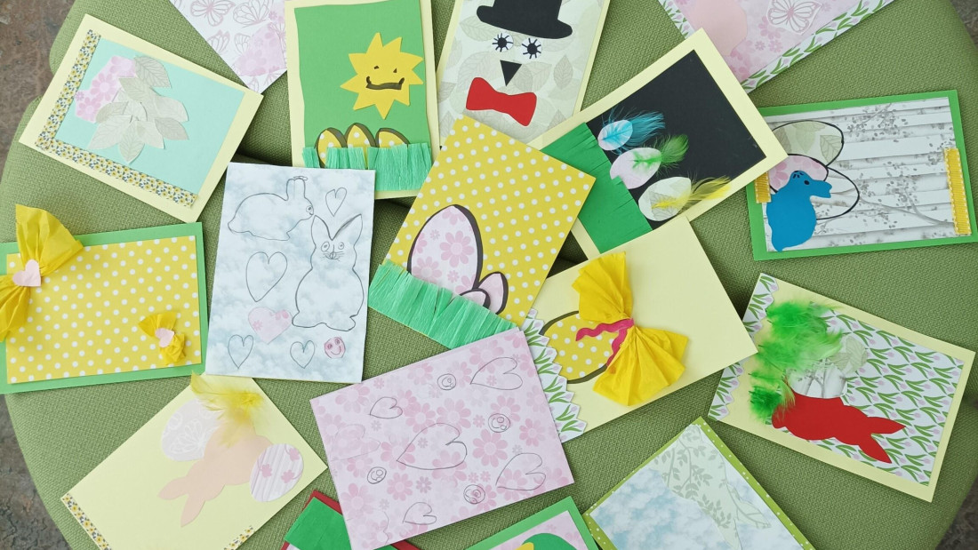 Vihreä-keltaisia pääsiäiskortteja ympyrässä vihreän kankaan päällä.