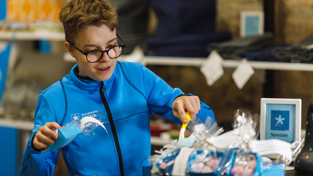 Spesian huppariin pukeutunut opiskelija järjestelee tuotteita Spesia Puodissa.