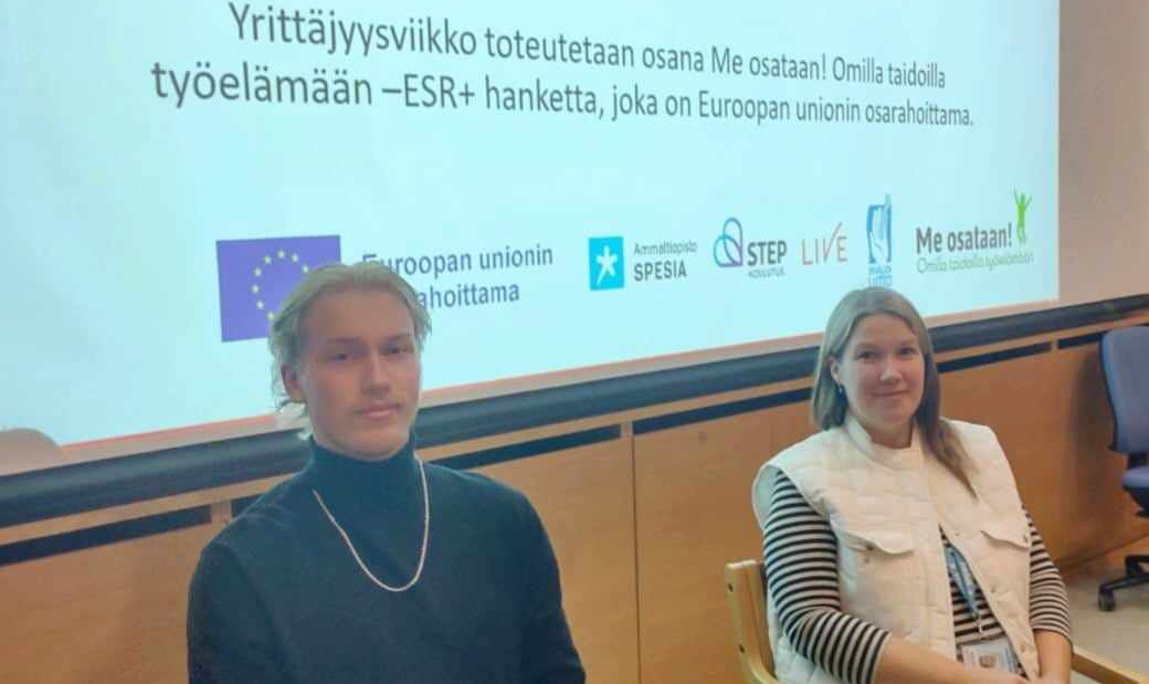 Esiintyjät odottamassa yrittäjyysviikon esittelyn alkamista Powerpoindia takanaan.