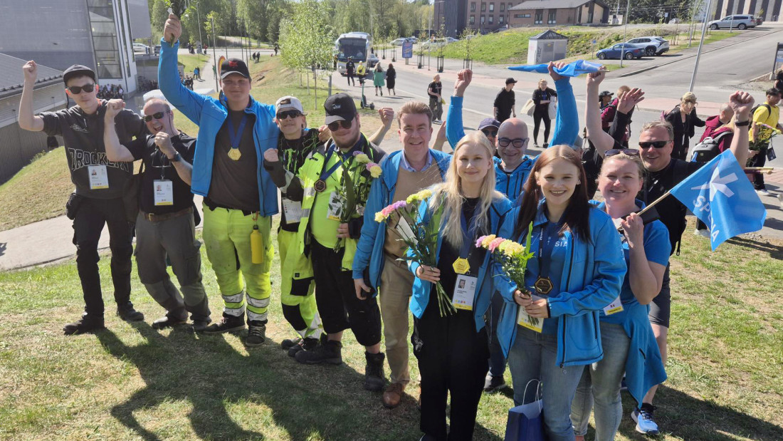 Ryhmäkuvassa Spesian mitalisteja, kilpailijoita ja huoltojoukkoja iloitsemassa Taitaja-mitalisteista.