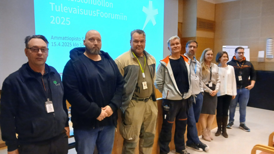 Useita henkilöitä seisoo rivissä.