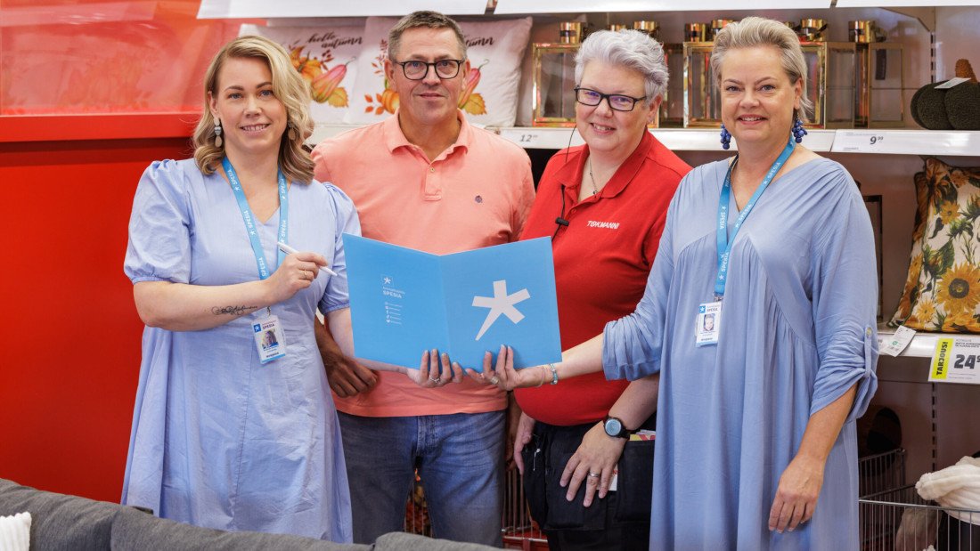 Spesian rehtori Annemari Suonsivu ja Koulutuspäällikkö Hanna-Mari Rajahalme yhdessä Tokmannin aluepäällikön Tuomo Pekkalan ja Turun myymäläpäällikön Satu Nymanin kanssa vierekkäin seisomassa ja pitävät Spesian kansiota yhdessä kädessä.