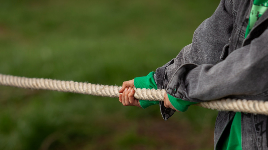 Kädet pitämässä kiinni paksusta köydestä.