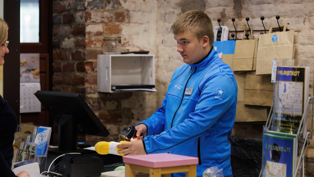 Opiskelija harjoittelee asiakaspalvelutyötä Puodissa.