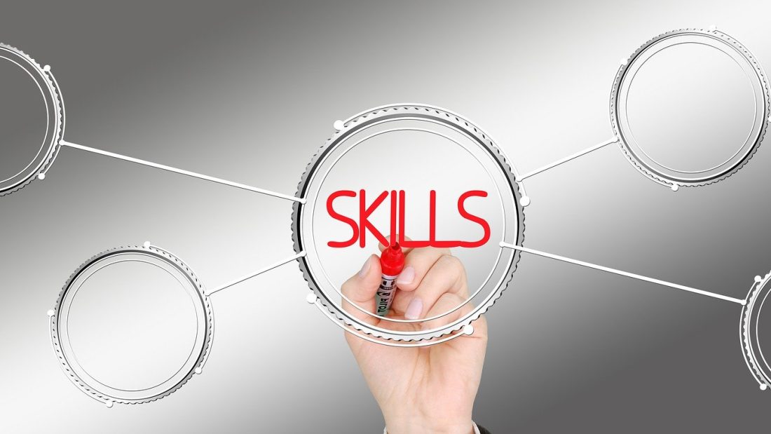 Käsi kirjoittaa punaisella tussilla sanan SKILLS ympyrän sisälle.