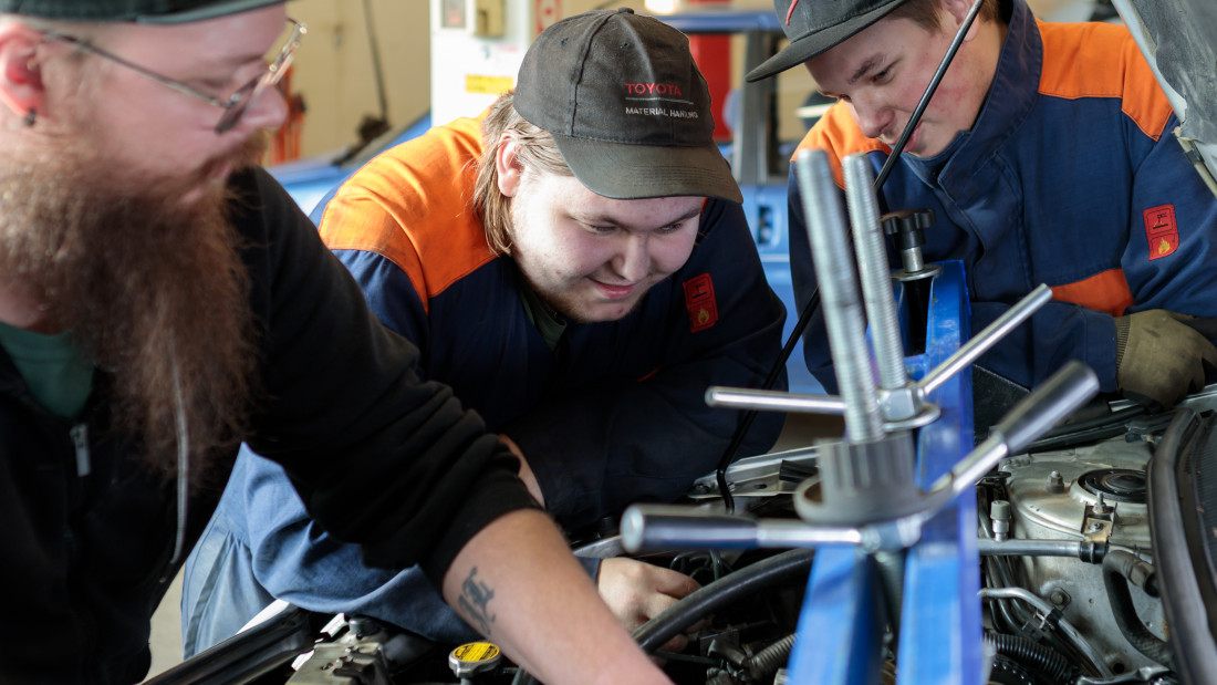 Kaksi opiskelijapoikaa korjaa autonmoottoria.