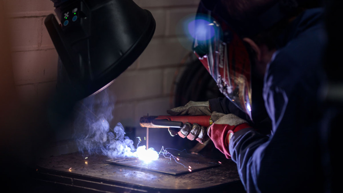 Hitsaus käynnissä, hitsaajalla turvavarustus päällään.