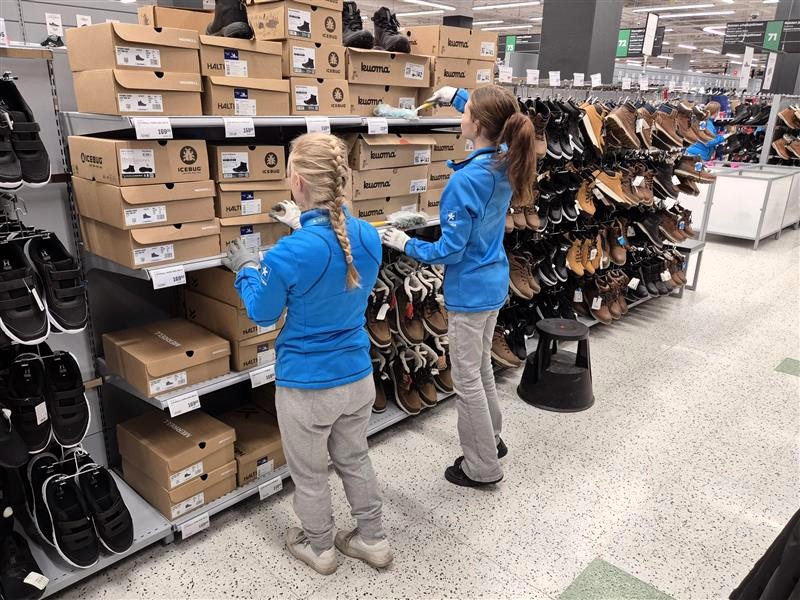 Spesian llogistiikan opiskelijat harjoittelemassa hyllytystä kenkäosastolla. 