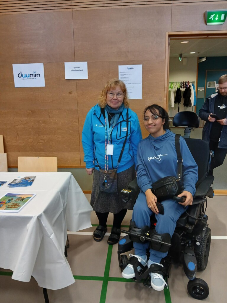 Spesian opiskelija ja ohjaaja messupisteellä. 