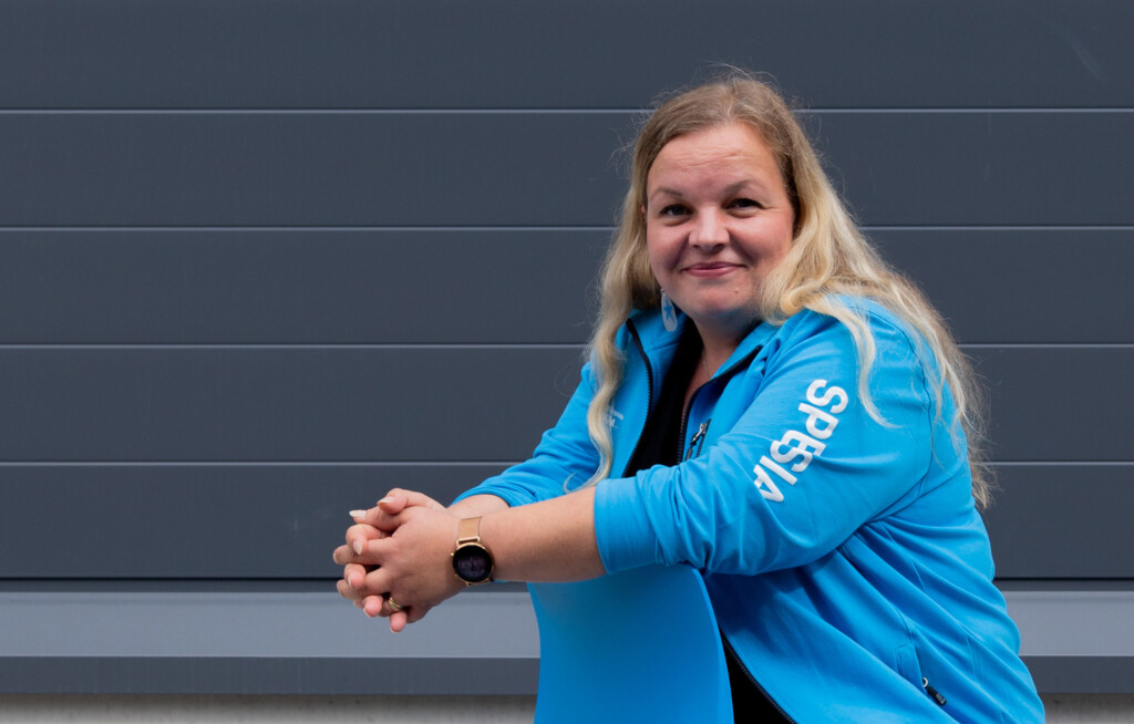 Spesian opinto-ohjaaja Annukka nojaa tuolin selkänojaan, päällään Spesian sininen huppari.