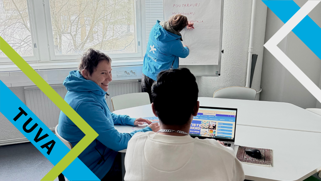 Kolme naista luokkahuoneessa, yksi kirjoittaa fläppitaululle ammatteja, yhdellä tietokone edessä.