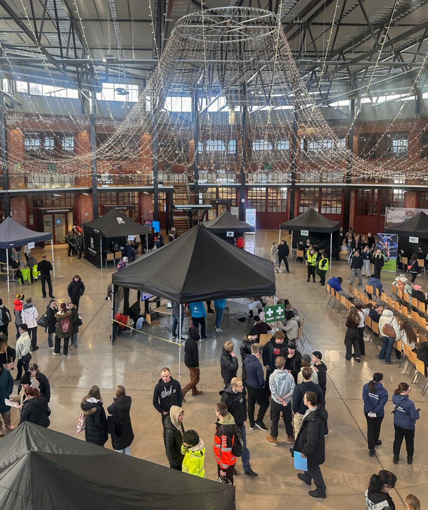 Tapahtumatelttoja ja ihmisiä Pieksämäen Veturitorilla. Kesätyökaruselli