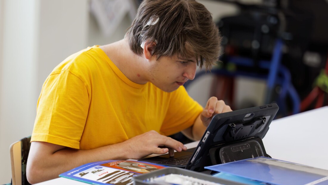 Henkilö tutkii tablettia.