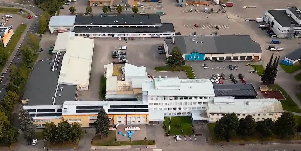 Luodaan vastausta 
Copilot said:

Kuvassa näkyy ilmasta kuvattu suuri rakennuskokonaisuus, jonka ympärillä on pysäköinti- ja piha-alueita.